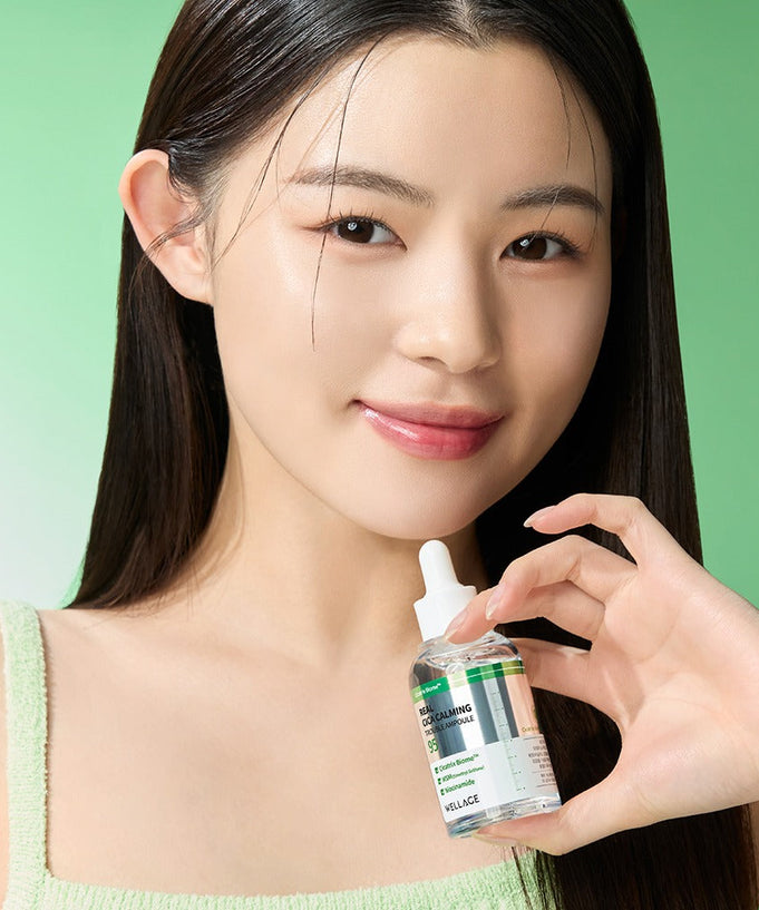 WELLAGE Real Cica Calming 95 Trouble Ampoule 50ml held by a smiling model against a green background for skincare promotion.