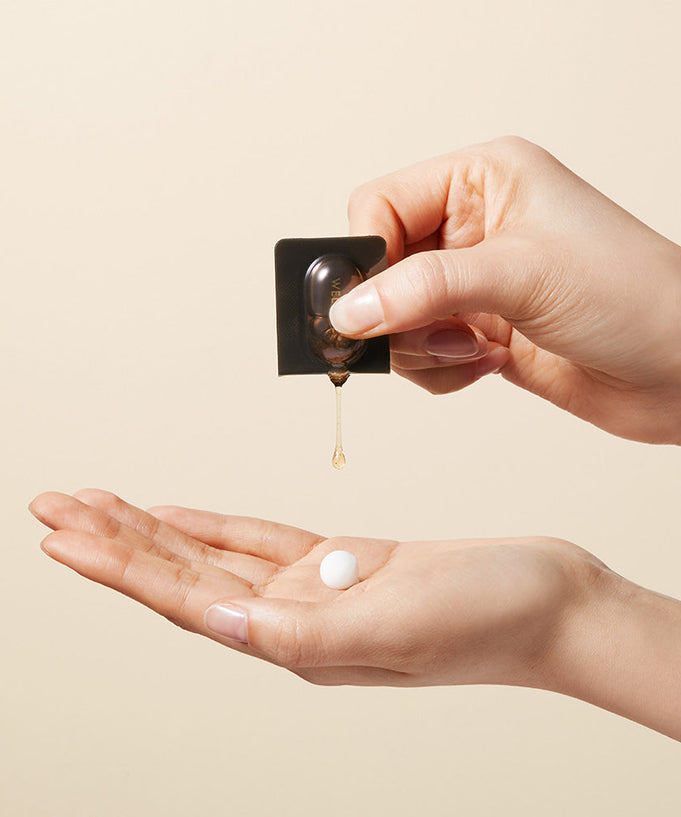 Applying WELLAGE Real Gold Collagen One Day Kit serum onto hand for skincare routine