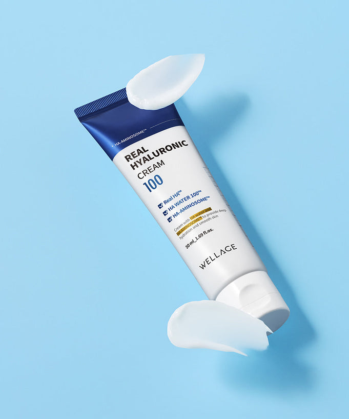 WELLAGE Real Hyaluronic 100 Cream 80ml tube on blue background with cream swirls.