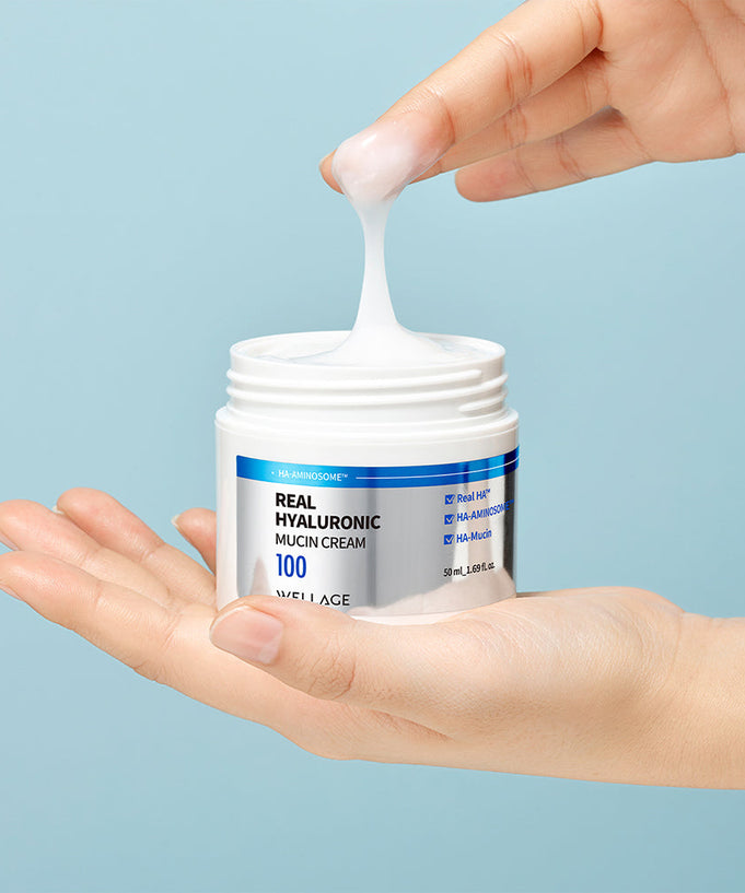 Person holding WELLAGE Real Hyaluronic Mucin Cream 50ml with cream being scooped from jar.