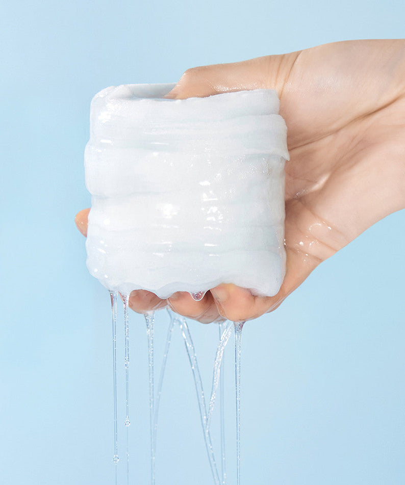 WELLAGE Real hyaluronic Blue Toner Pads 70 Sheets being squeezed with liquid dripping from a hand