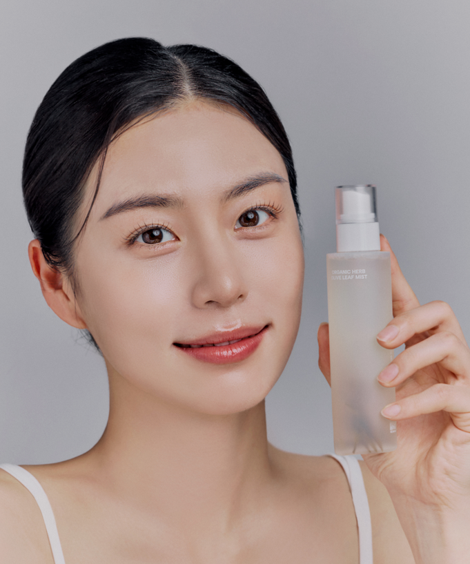 Model holding WHAMISA Organic Herb Fermented Olive Leaf Mist 100ml bottle