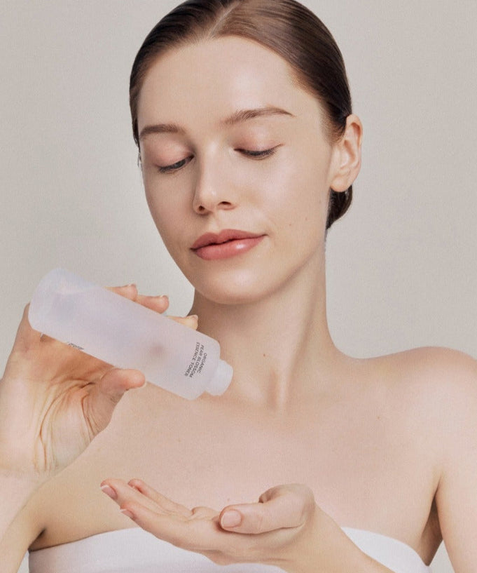 Model applying WHAMISA Organic Pear Blossom Fermented Essence Toner 160ml to hand