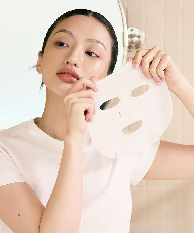 Woman holding WHIPPED Butter Vegan Glow Barrier Squeeze Mask 1ea ready to apply on face for skincare routine.