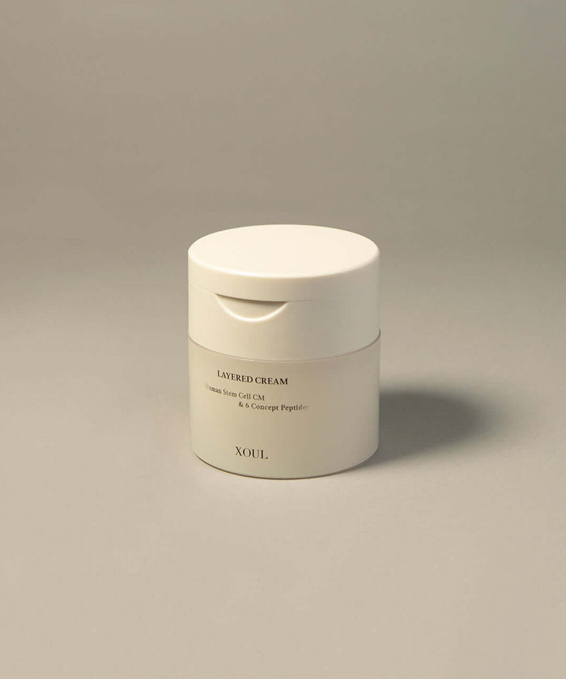 XOUL Layered Cream 50g white jar on gray background. Anti-aging skincare product with peptide formula.