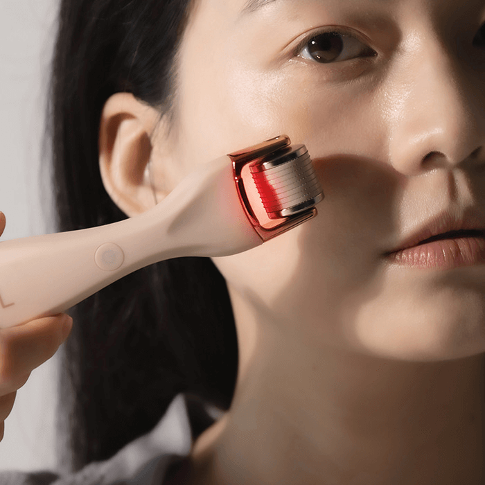 Woman using XOUL MTS Microneedle Device on her face for skincare treatment