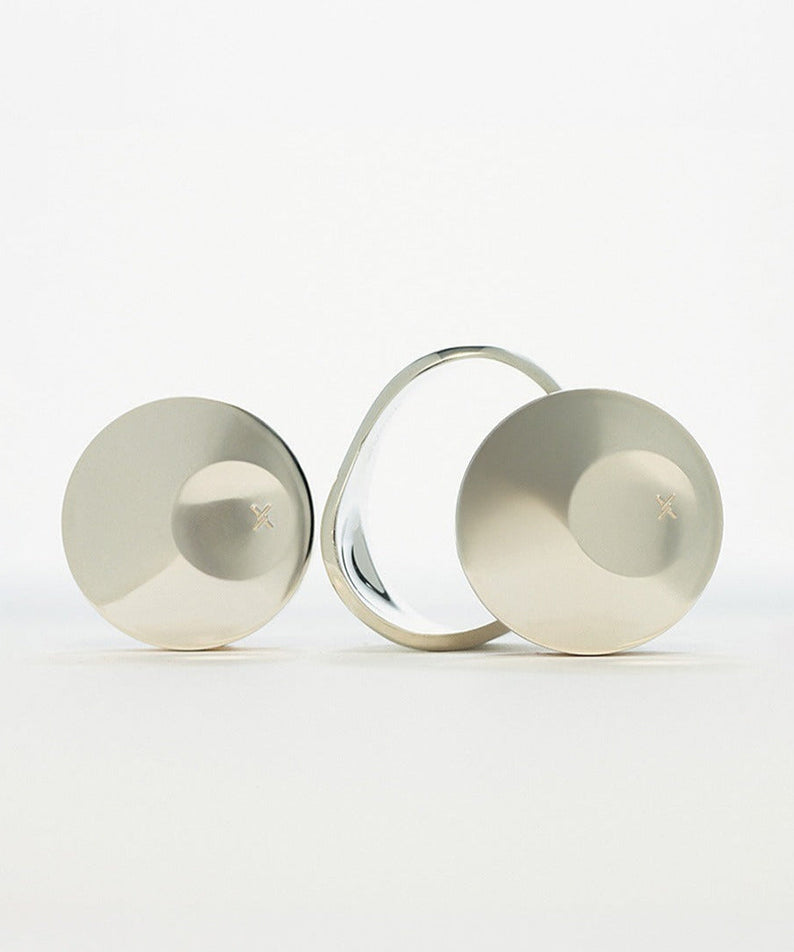 Silver disc-shaped objects with a mirrored surface on a white background.