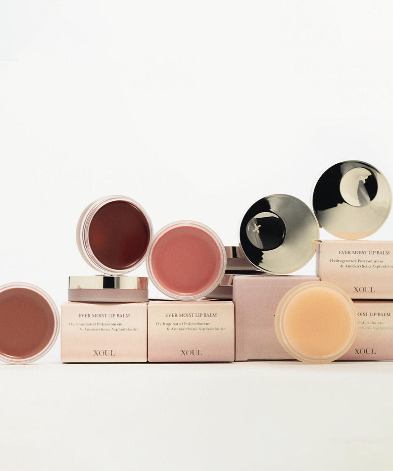 XOUL Ever Moist Volume Lip Balm 8g - Variety of lip balms in containers with pink boxes, showcasing different shades and packaging.