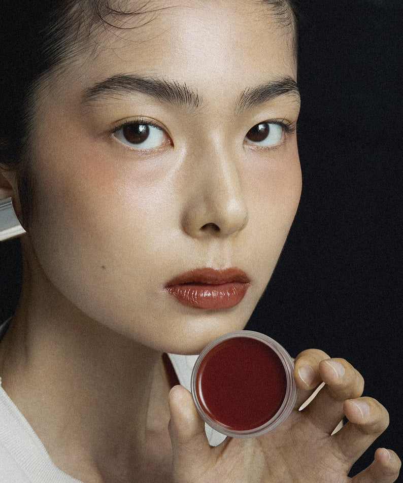 Close-up of a person holding XOUL Ever Moist Volume Lip Balm 8g, showcasing its color and texture.