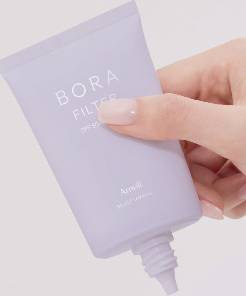 Person holding AMELI Complement Series Bora Filter 50ml tube.