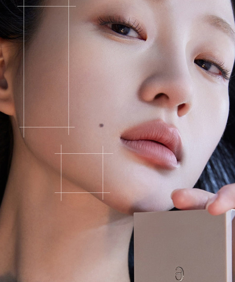 Close-up of a person holding a makeup product, showcasing AMELI Maroon Shading, emphasizing smooth skin and elegant packaging.