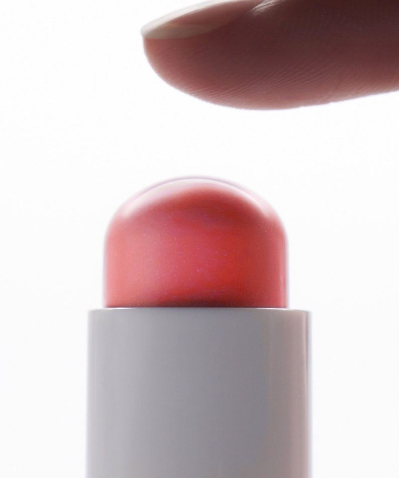 Finger touching AMELI Night Series Touch Balm, a luxury skincare product for nighttime use.