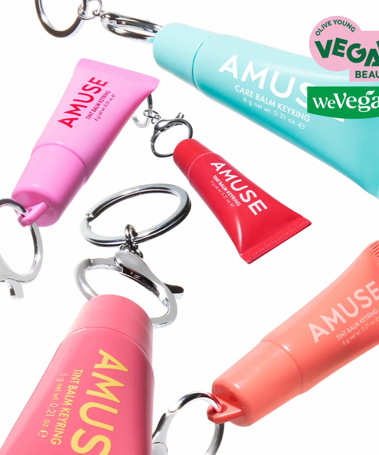 Colorful vegan AMUSE TINT BALM KEYRING collection displayed with keyring attachments, highlighting unique colors and eco-friendly design.