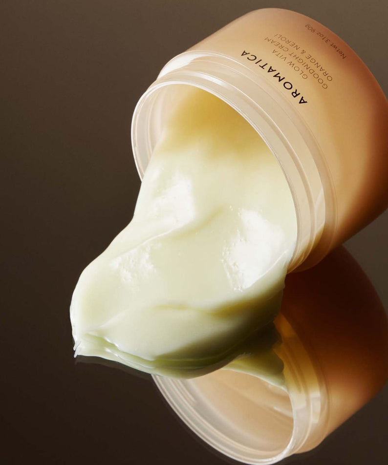 AROMATICA Glow Vita Good Night Cream Orange & Neroli 90G jar with cream spilling out on glossy surface