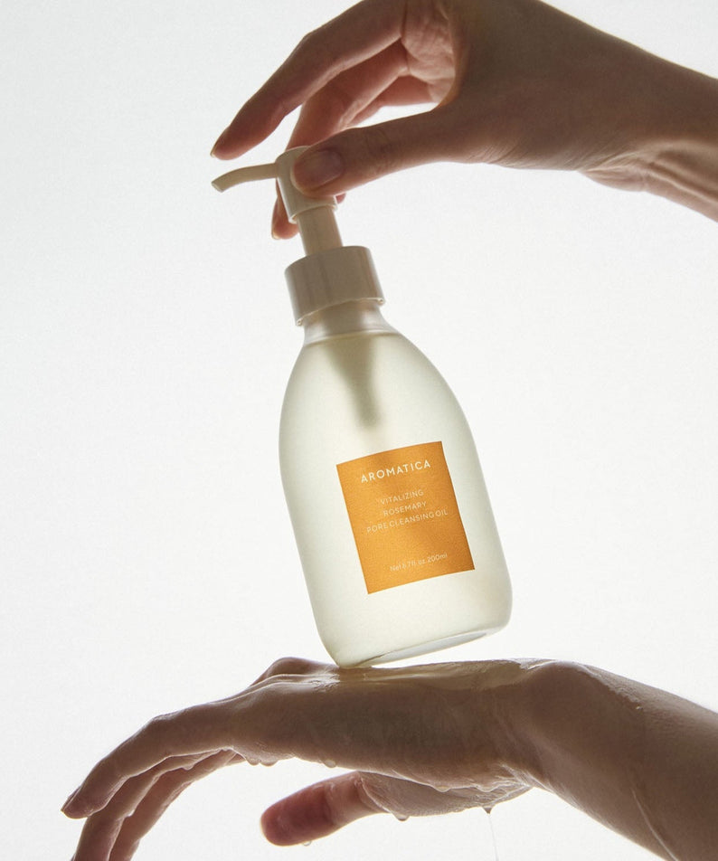 Hands using AROMATICA Vitalizing Rosemary Pore Cleansing Oil 200ML pump bottle