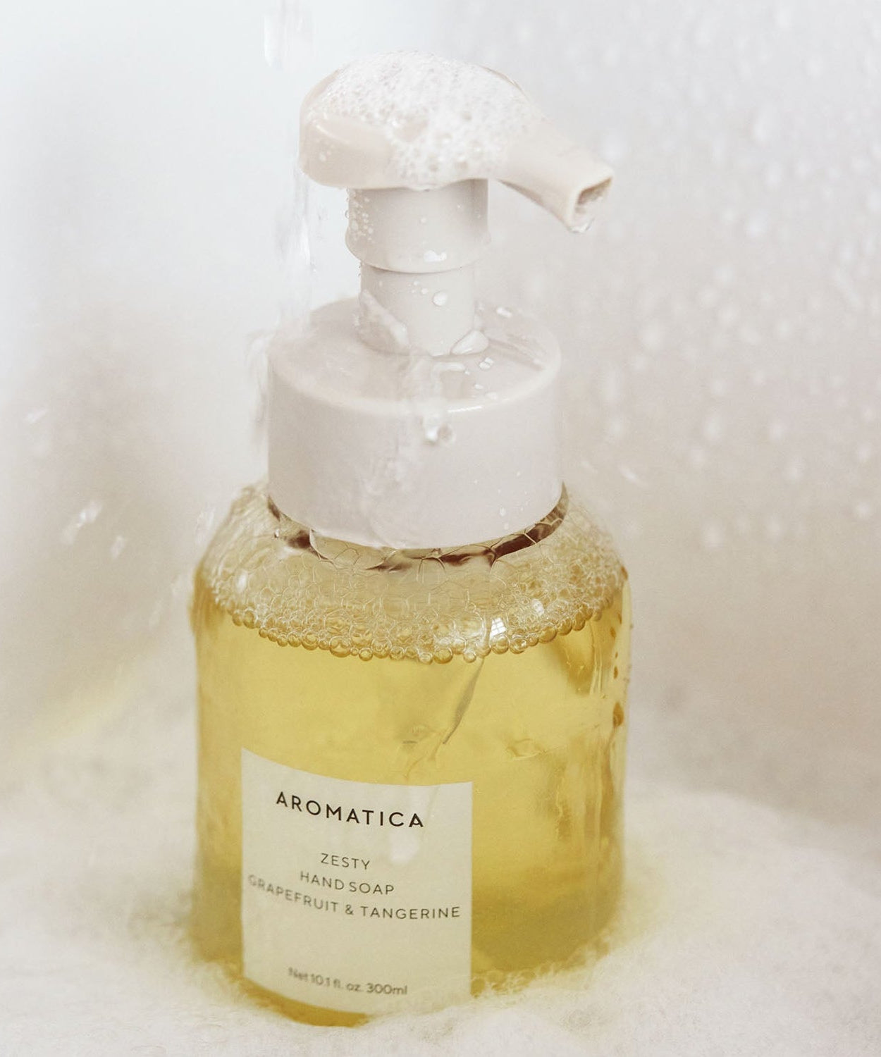 AROMATICA Zesty Hand Soap Grapefruit & Tangerine 300ML bottle with foaming pump in a bath setting