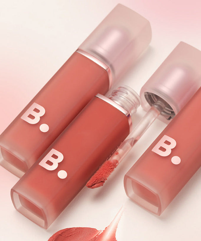BANILA CO New Sheer Velvet Veil Tint bottles open with applicators visible on a pink background.