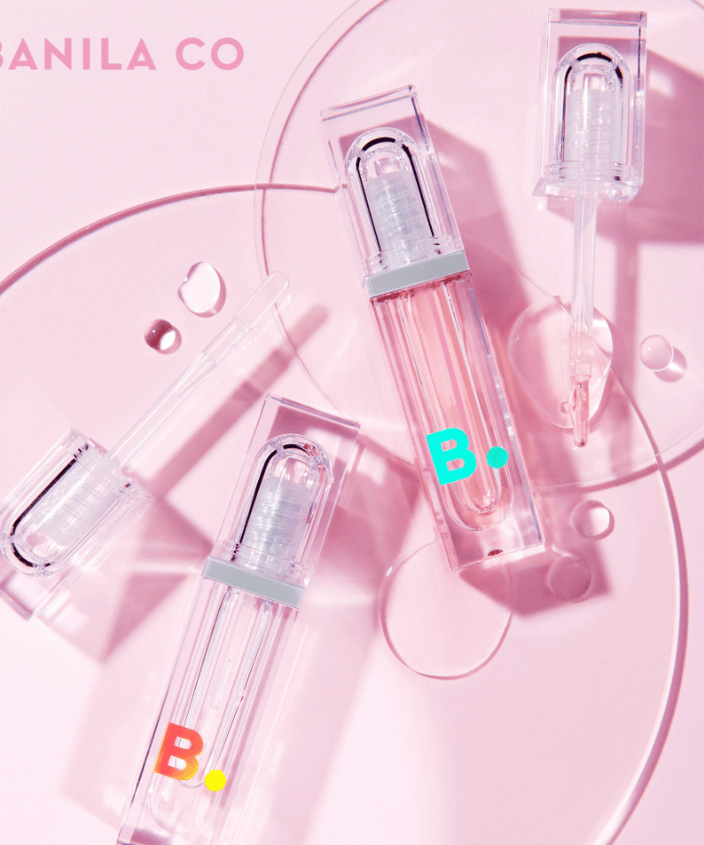 BANILA CO Volume Lip Plumper on a pink background with clear and pink packaging, enhancing lip fullness and shine.