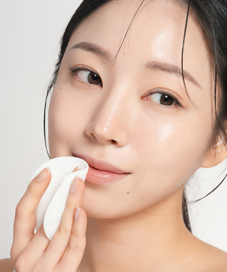 Woman using BARULAB Rice Bran Ceramide Cream In Cleansing Pads 30 sheets on her face for gentle cleansing and hydration.