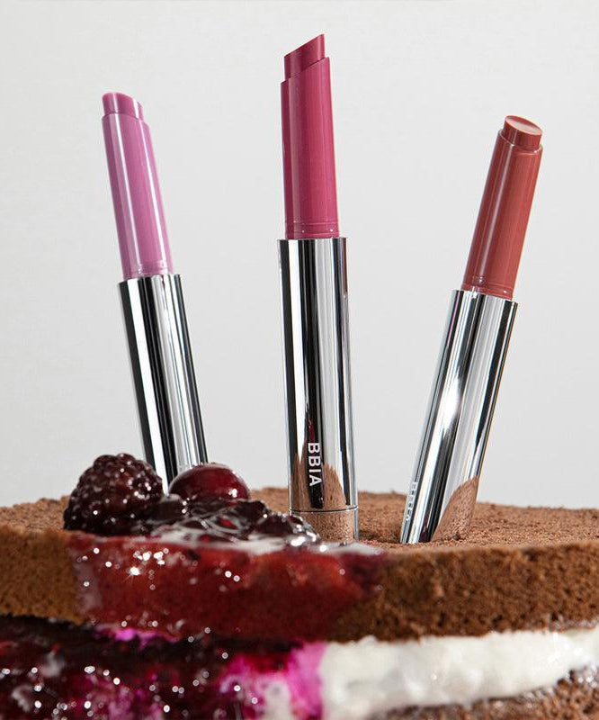 BBIA Over Glaze Stick displayed on a chocolate cake with berry topping, showcasing three vibrant shades in sleek packaging.