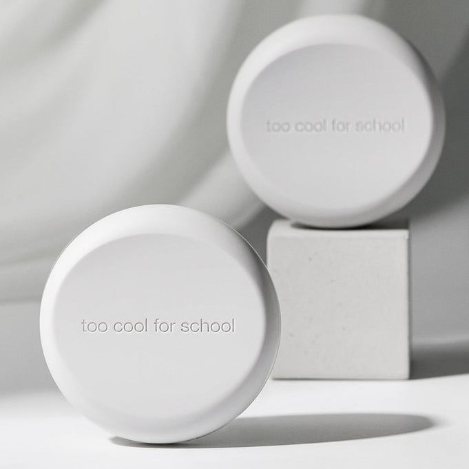 TOO COOL FOR SCHOOL Art Class Fixing Cover Cushion in minimalist packaging displayed on a pedestal.