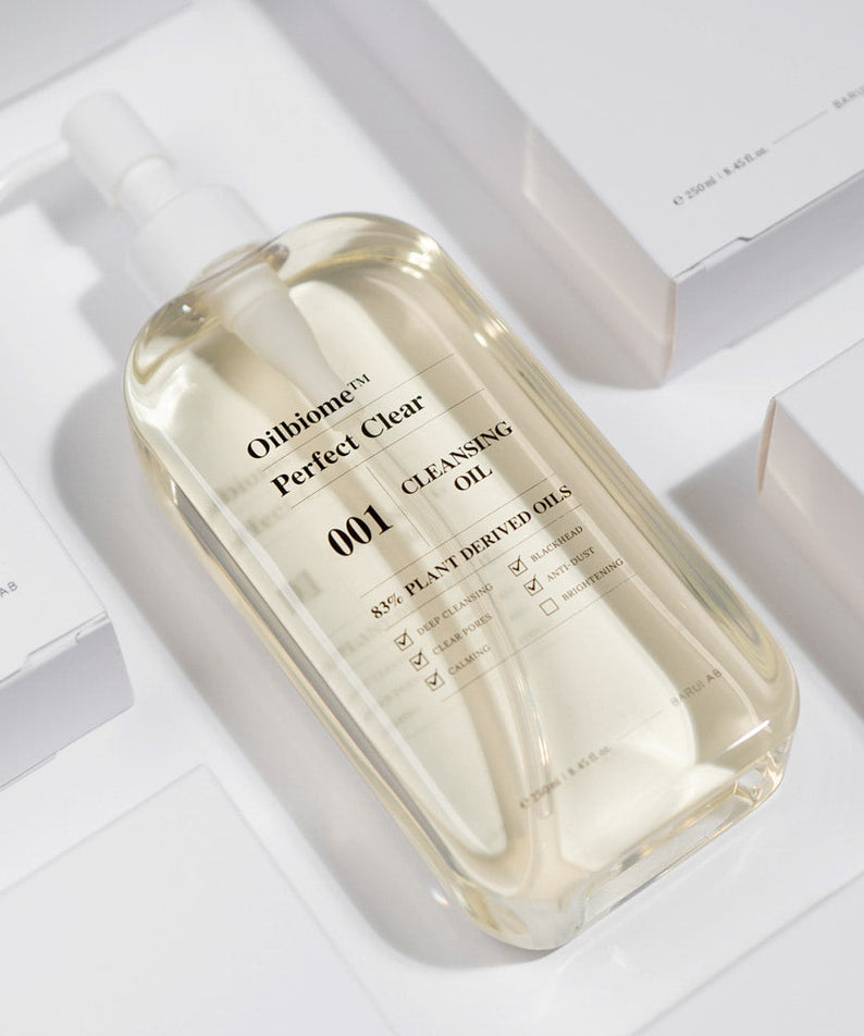 BARULAB Oilbiome Perfect Clear Cleansing Oil 250ml bottle in bright light surrounded by packaging, showcasing product design and clarity.