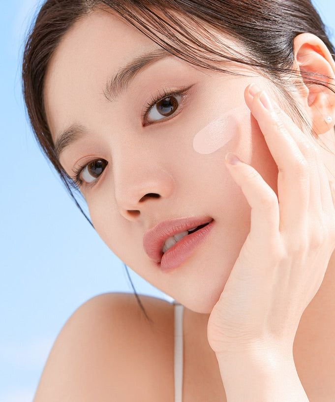 Woman applying CORALHAZE SIlky Glow Tone Up Base for radiant skin