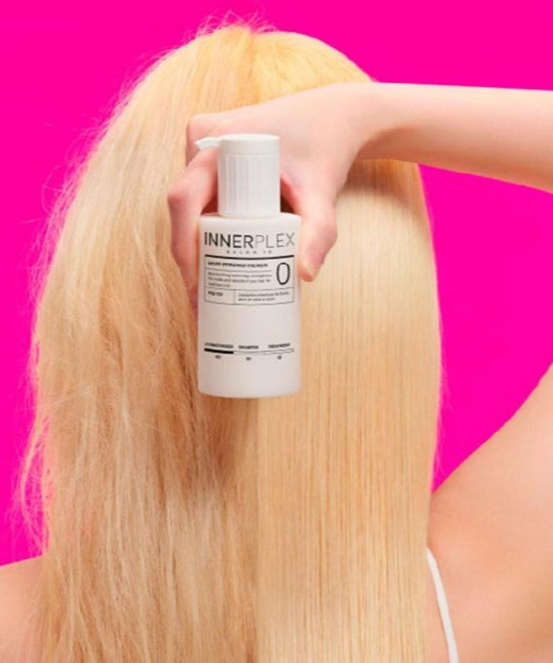 Blonde hair with MISE EN SCENE Innerplex Hair Strengthener 145g Plan held against pink background