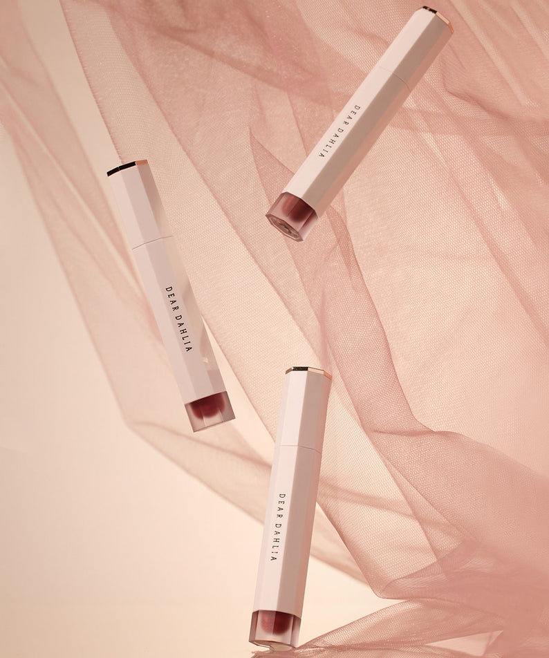 Three DEAR DAHLIA Dream velvet Lip Cloud tubes with pink fabric background