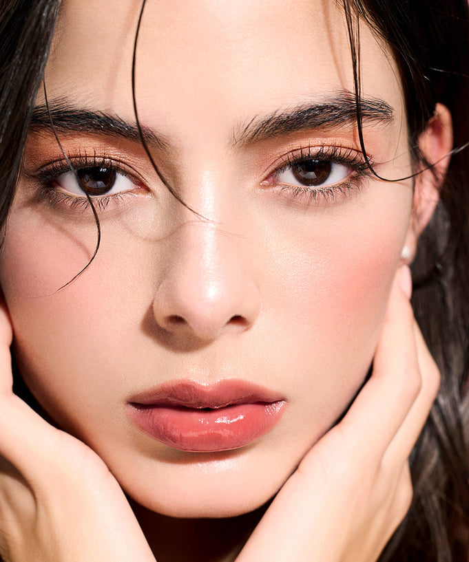 Model wearing DEAR DAHLIA Lip Paradise Sensual Lip Glow with glossy finish.