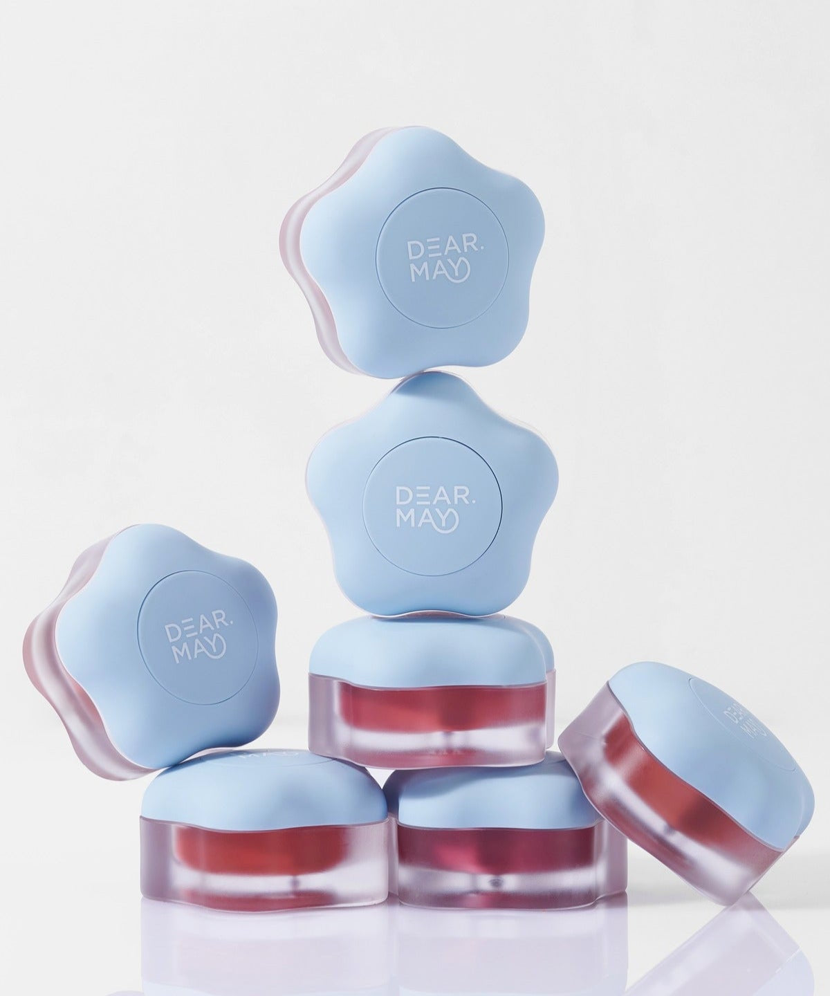 Stack of DEAR MAY Pure Falling Mood Lip Pot 6.5g containers with blue lids and product name visible, designed for mood enhancement.