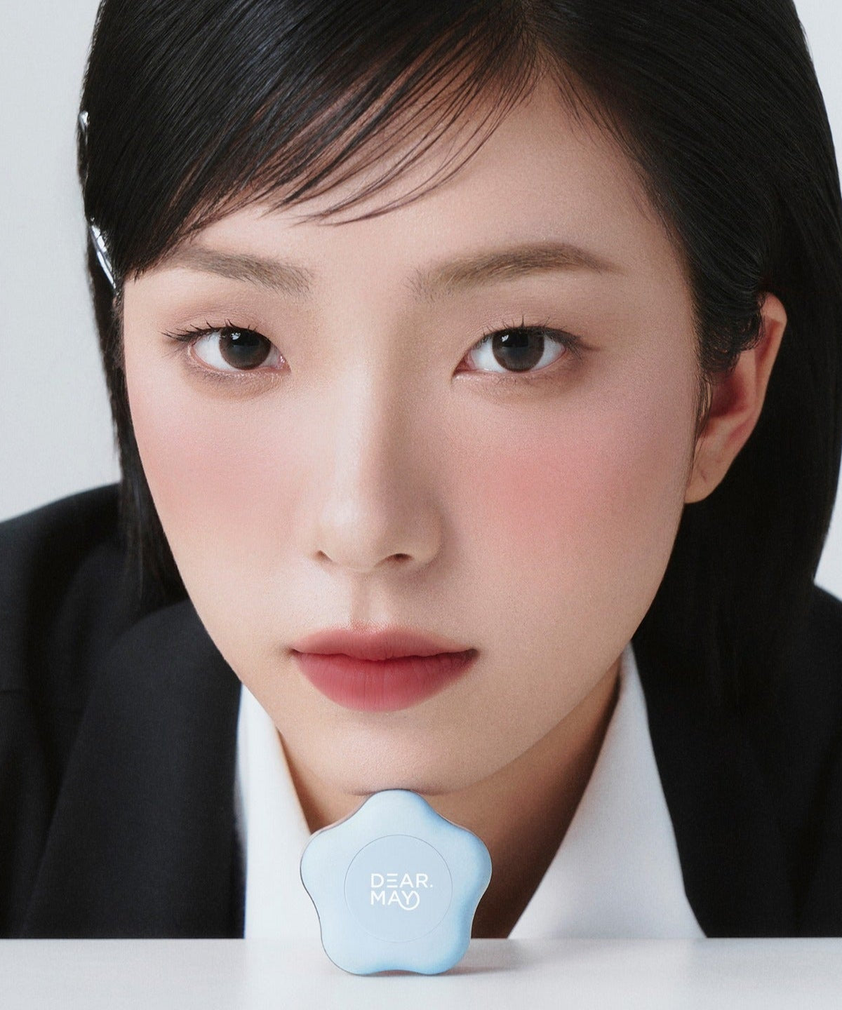 A close-up of a person showcasing DEAR MAY Pure Falling Mood Lip Pot 6.5g with a blue container in front.