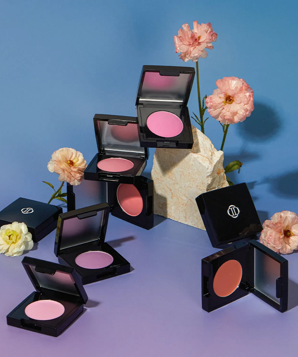 Display of DINTO Be My Wendy Blusher surrounded by flowers on a purple and blue background.