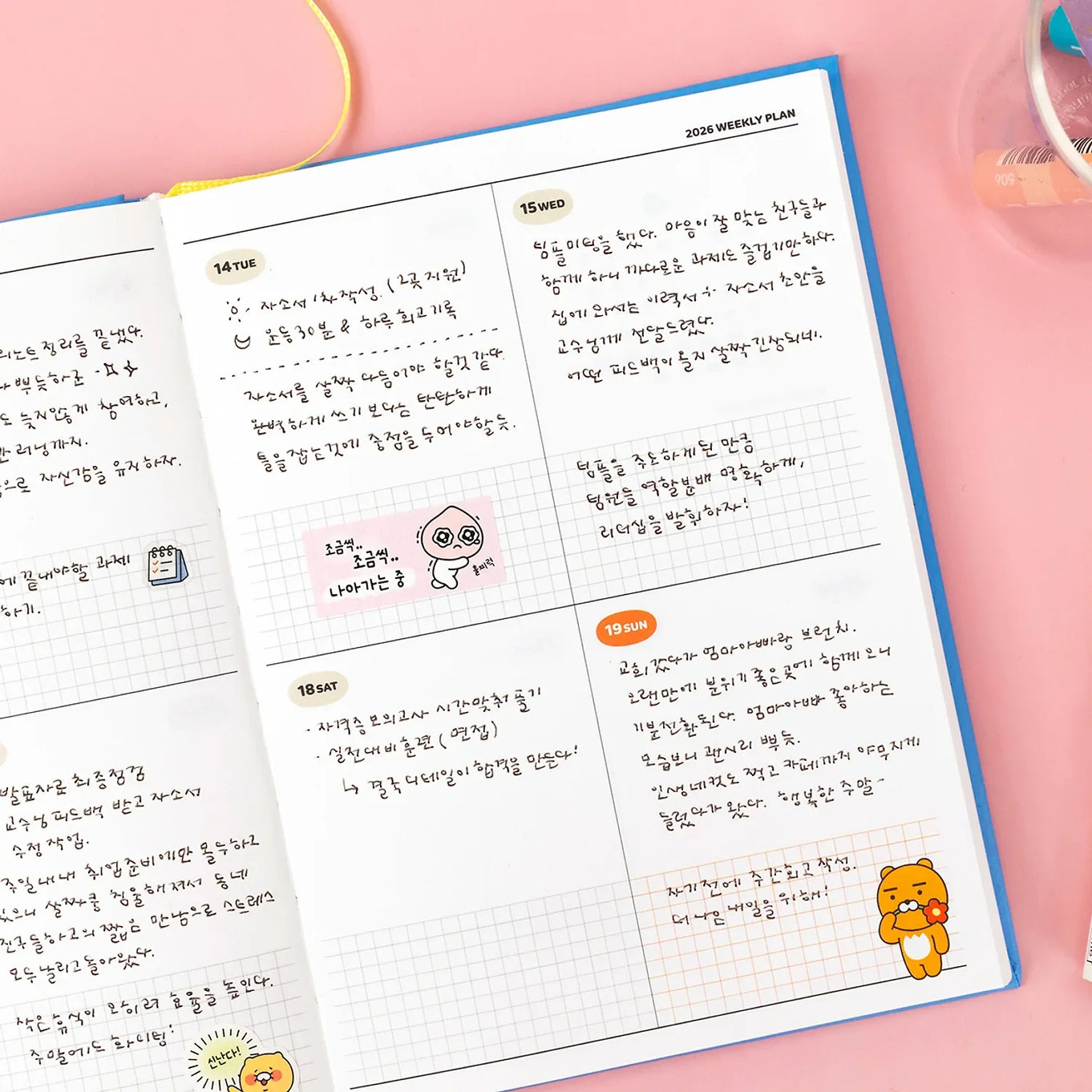 Open pages of KAKAO FRIENDS Planner 2026 showing weekly layout with illustrations on a pink background.