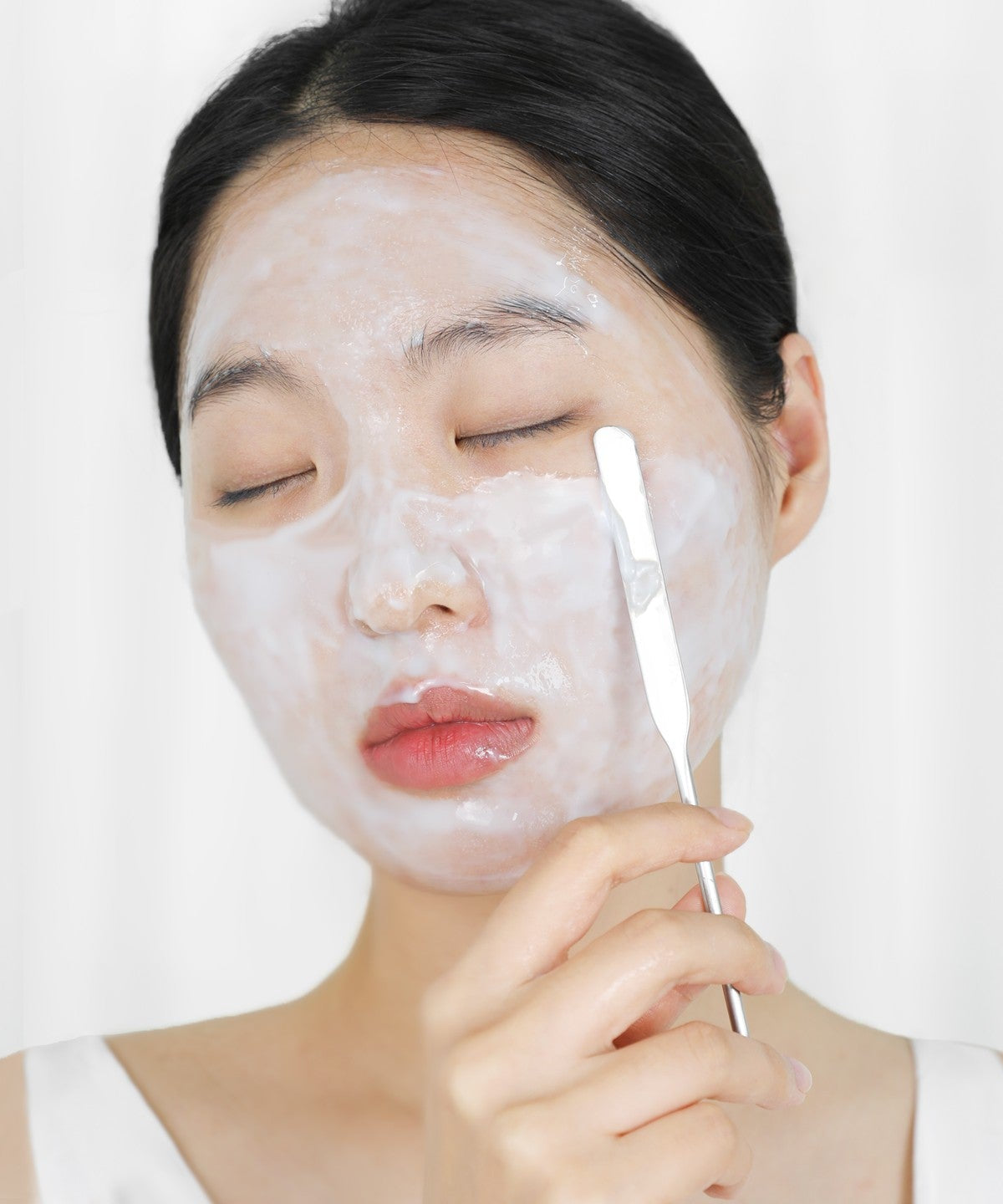 Applying ELIZAVECCA Aqua Water Snail Mushine Cream with a spatula on face for hydrating skincare routine.