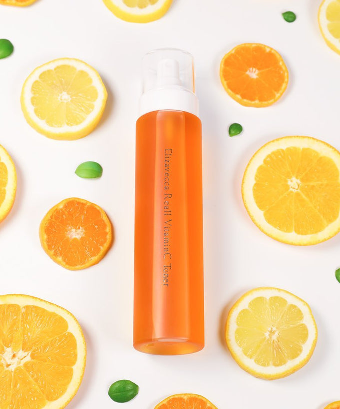 ELIZAVECCA Real One Vitamin C Toner 200ml bottle surrounded by citrus fruits on white background