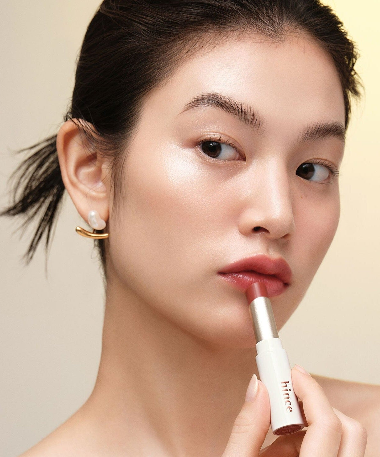 Model applying HINCE Mood Enhancer Lip Glow