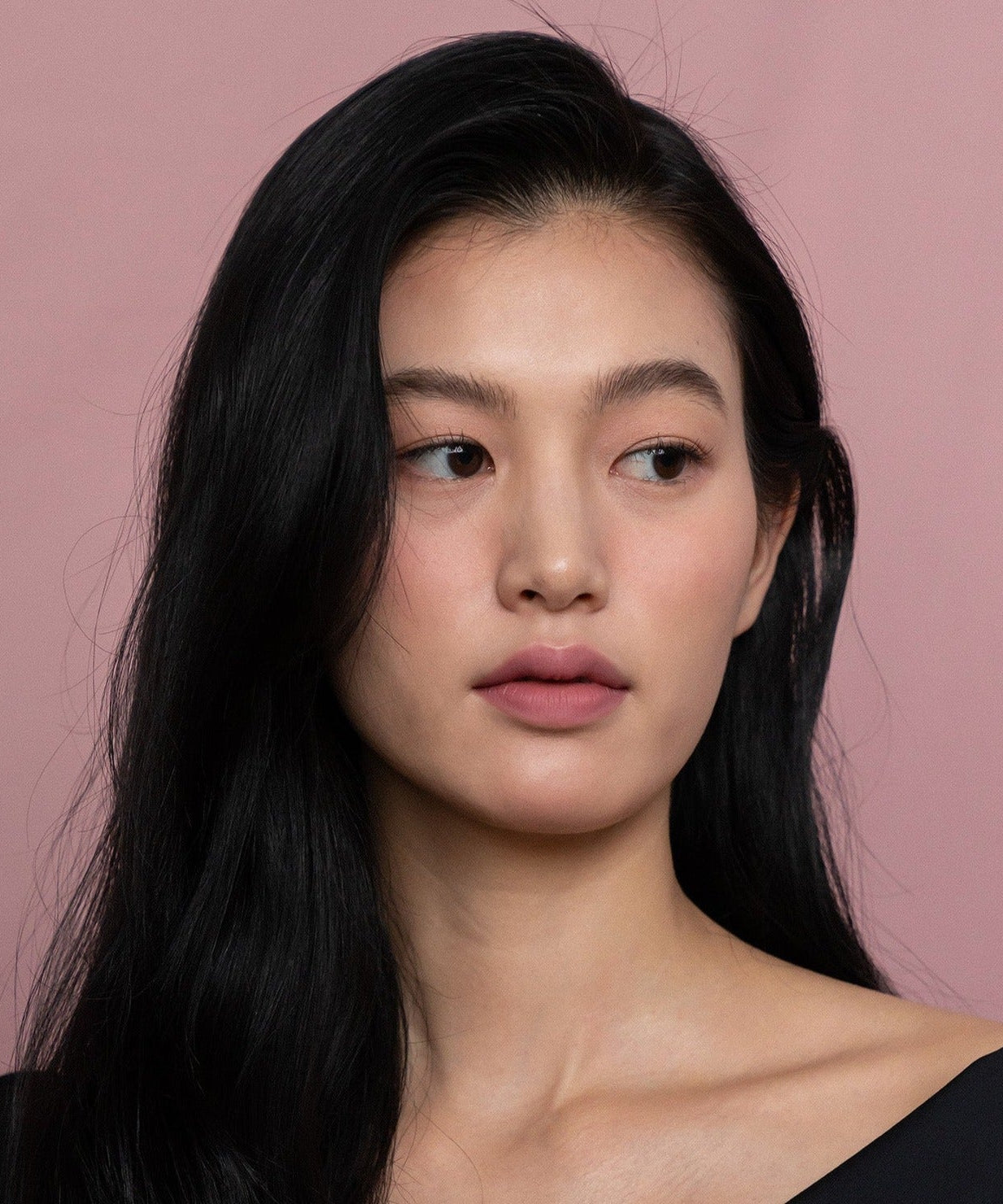 Model wearing HINCE Mood Enhancer Matte lipstick with soft pink background