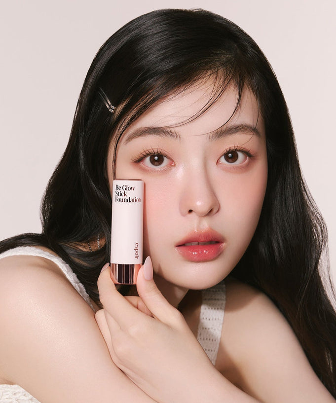 Woman holding ESPOIR BE GLOW STICK FOUNDATION SPF50+ PA++++ product.
