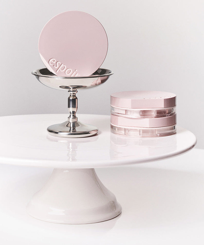 ESPOIR Be Natural Cushion SPF50+ PA++++ displayed on a modern stand, highlighting chic design and premium packaging.