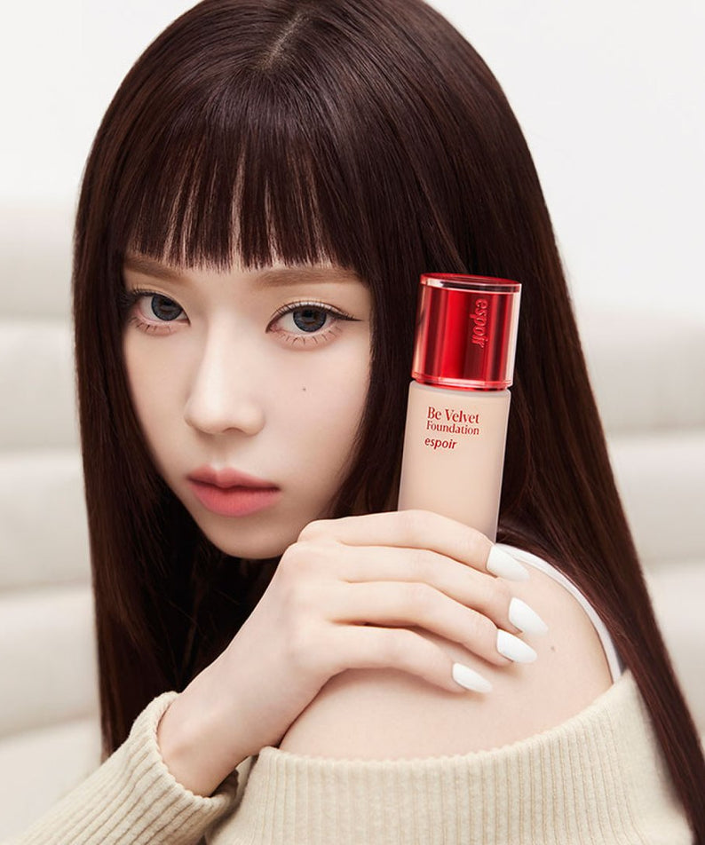 Model holding ESPOIR BE VELVET FOUNDATION SPF22 PA++ showcasing luxurious skin coverage.