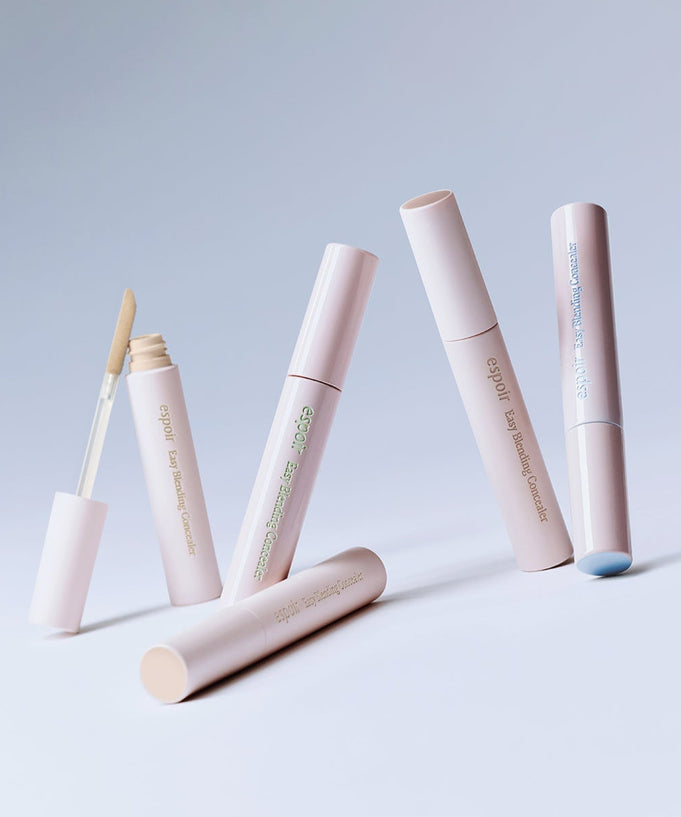 Four tubes of ESPOIR EASY BLENDING CONCEALER on a light background, showcasing their sleek design and applicator.