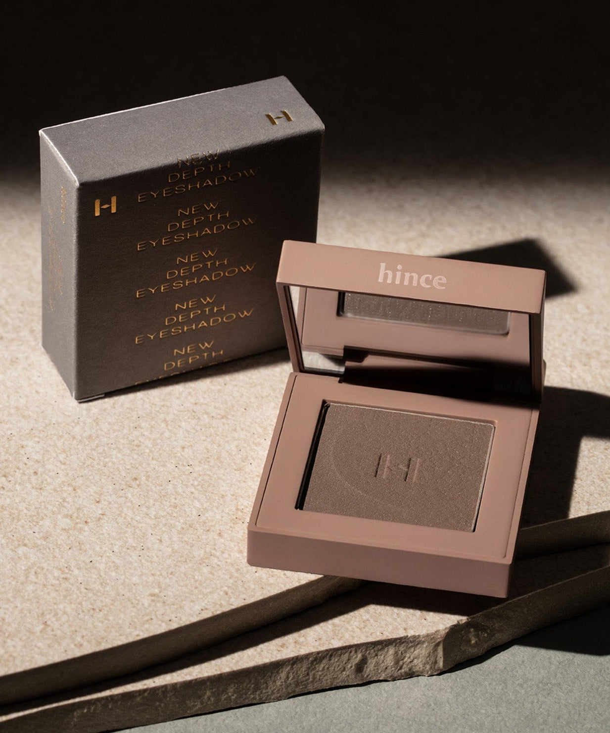 HINCE New Depht Eye Shadow compact and packaging on a textured surface.