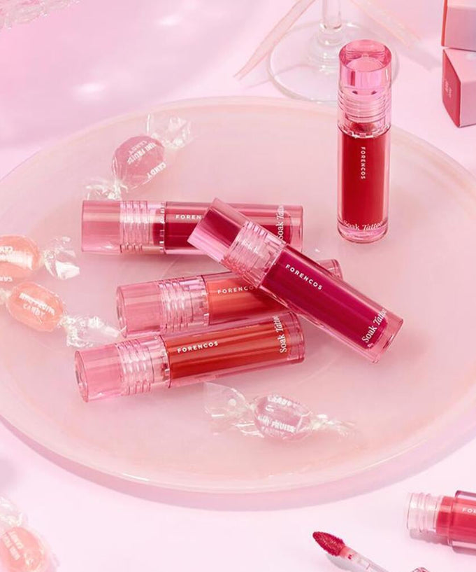 FORENCOS Renewal Tattoo Tint lip colors arranged on a pink plate with candies, showcasing vibrant shades for long-lasting wear.