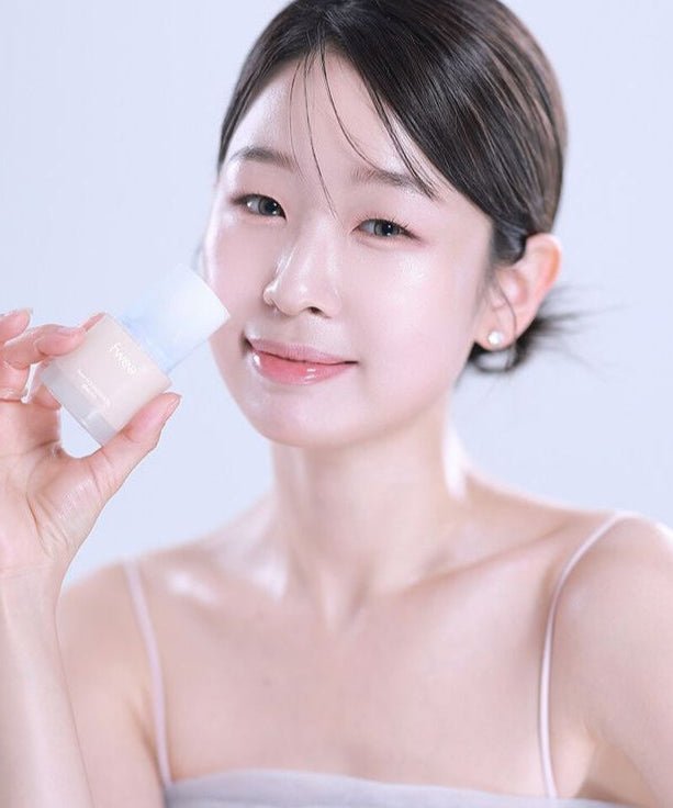 Person holding a bottle of FWEE Foundation Glass, showcasing the product's design and appearance.