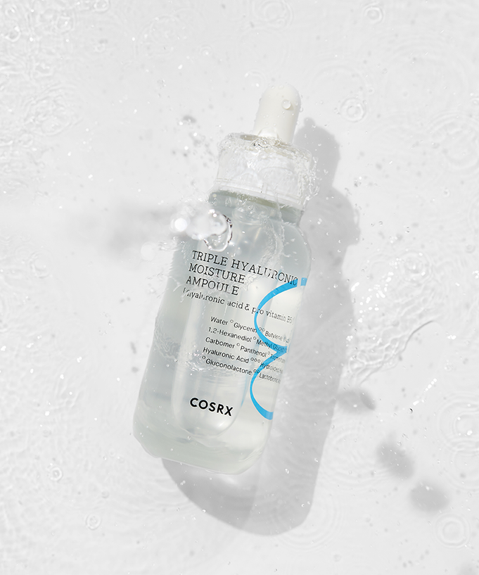 Bottle of COSRX Hydrium Triple Hyaluronic Moisture Ampoule 40ml with water droplets