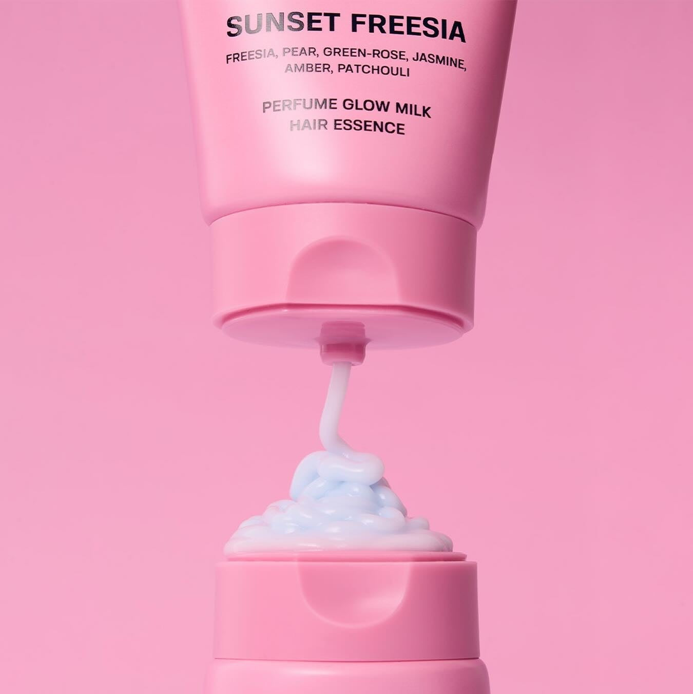 JULYME Perfume Glow Milk Hair Essence 80ml (Sunset Freesia) in pink bottle with creamy texture, perfect for luxurious hair care.