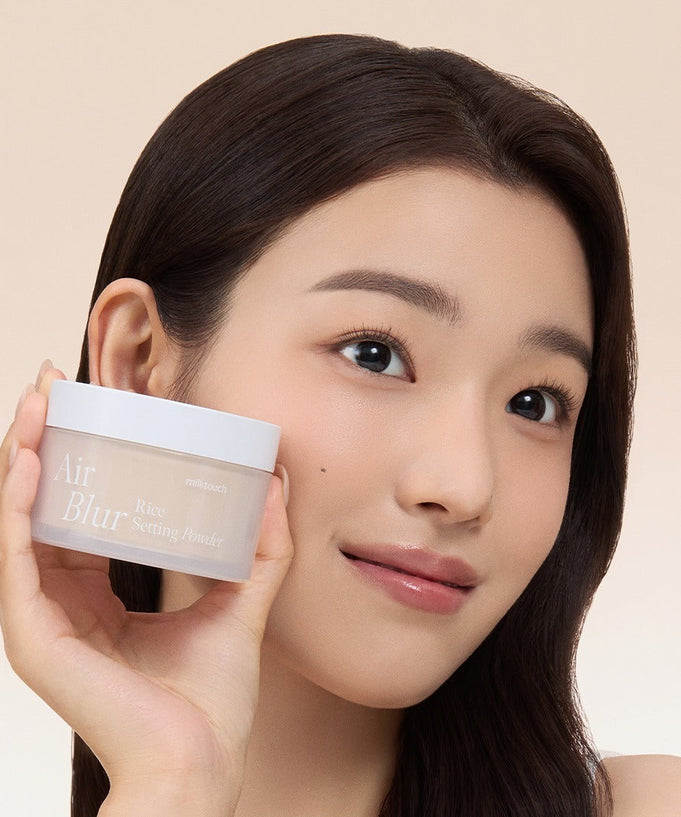 Woman holding MILK TOUCH Air Blur Rice Setting Powder with a smile