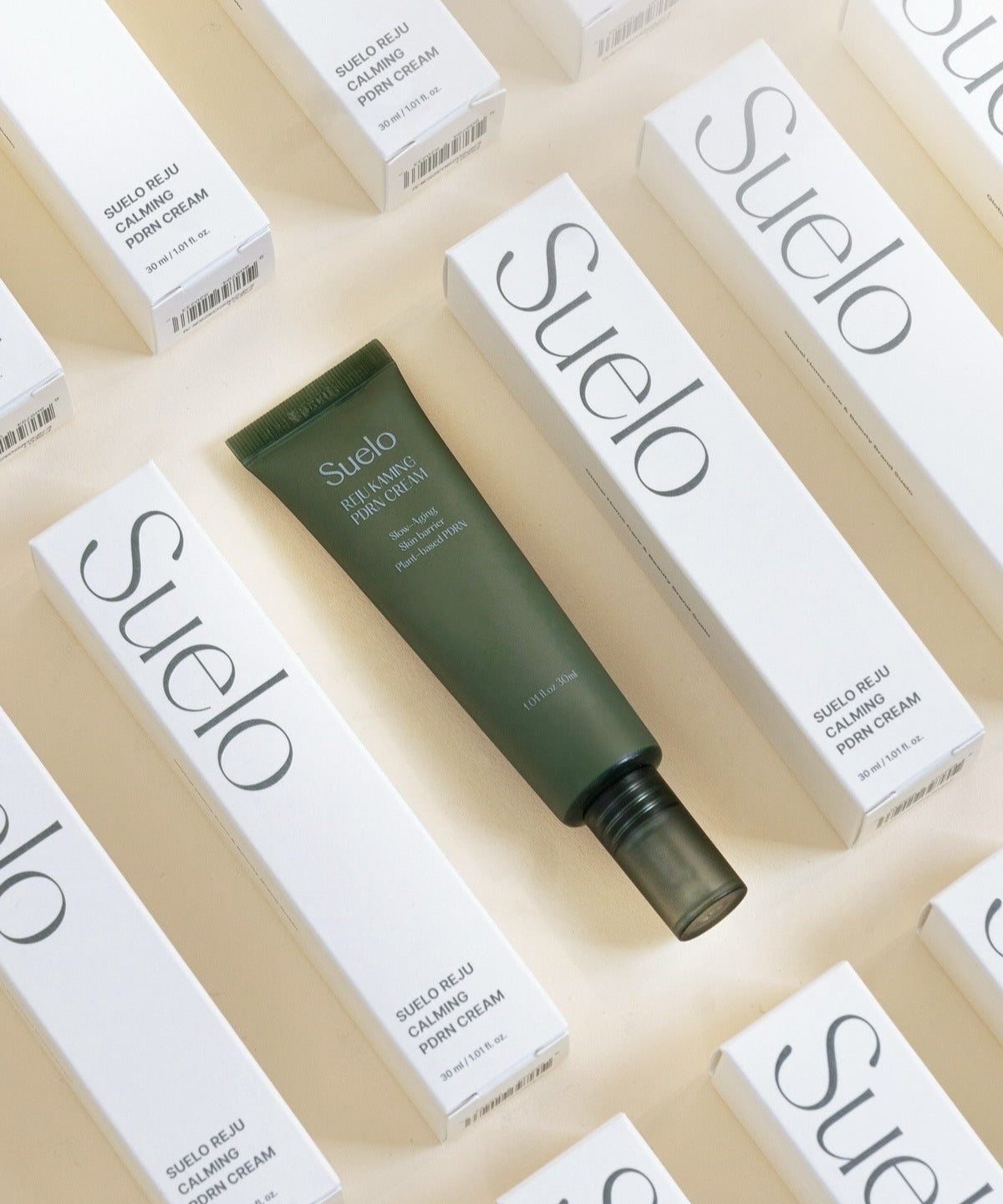 SUELO Reju Calming PDRN Cream 30ml in green tube with packaging boxes arranged around it