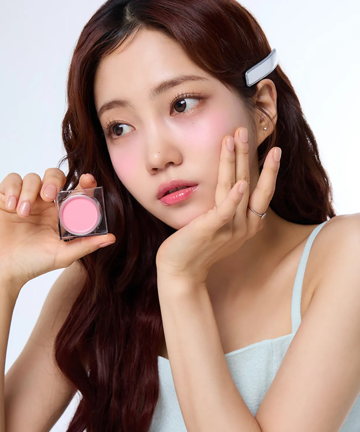 Woman holding IVI MAD PEACH Mood Mix Cream Blusher showcasing product application.